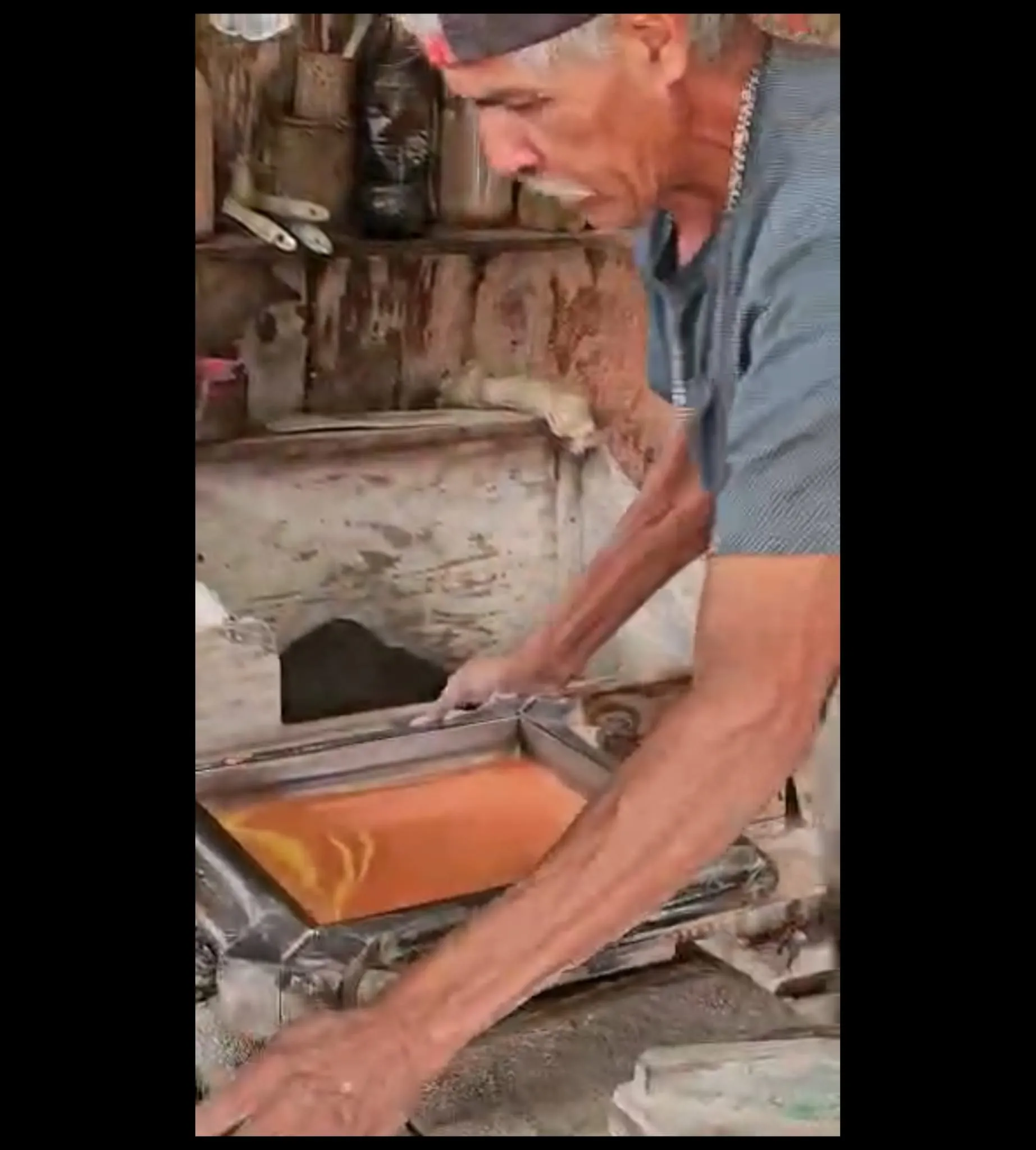 Artisan shaping a fresh terracotta tile by hand in the workshop